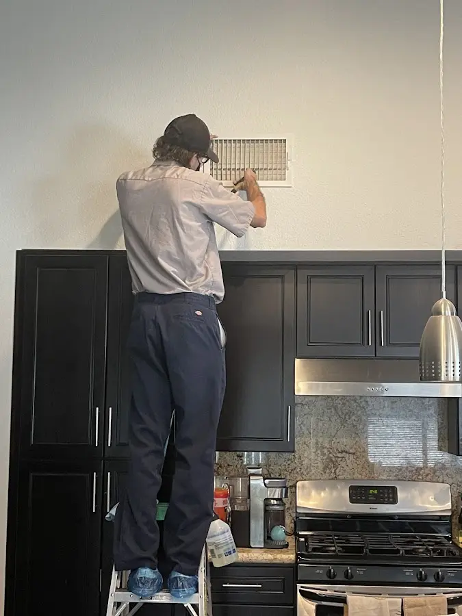 Technician inspecting an air vent during HVAC service in Fairfield